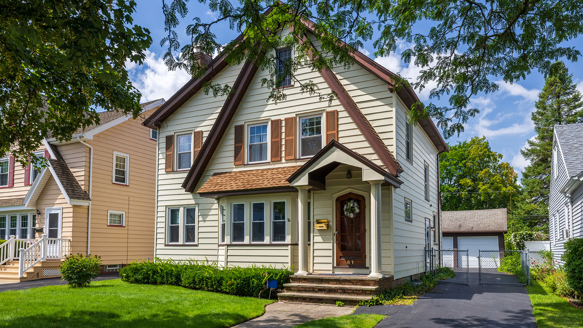 A beautiful city house with a lawn and trees. Home Selling Assistance - Your Path to a Successful Sale!