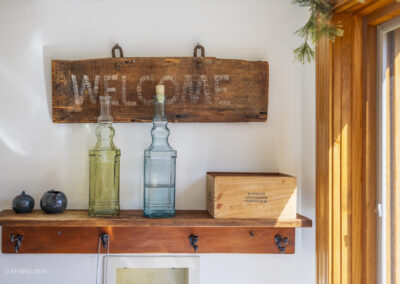 Transition to senior living: celebrating new beginnings. A sunny window with colored bottles & welcome sign on a wooden shelf