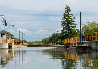 Erie canal lock 33 in brighton, ny, with yellow lock gates and calm water on a clear day.