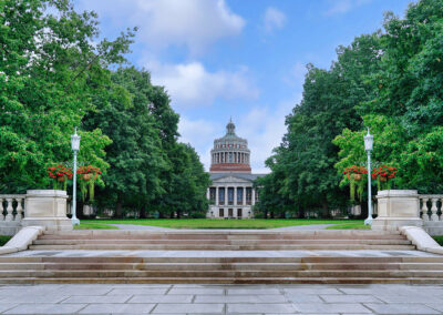 View of the university of rochester’s rush rhees library framed by trees along the eastman quad walkway