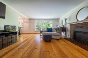 415 Oakridge Drive, Rochester, Ny 14617 3 Sun-filled living room with hardwood floors, picture window, and gas fireplace at 415 oakridge drive