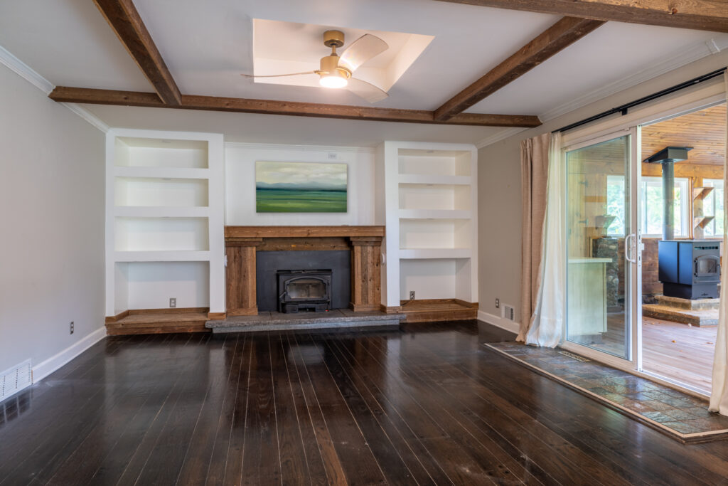 19 Warder Drive, Pittsford, Ny 14534 3 Sunken family room with exposed beams, built-in shelving, wood-burning stove, and access to the three-season room.