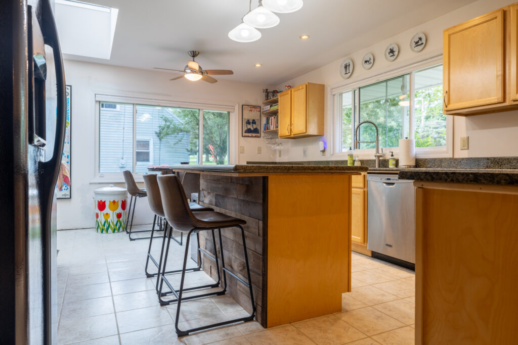 166 Moseley Rd, Fairport, NY 14450 5 Kitchen with wood cabinetry, center island, breakfast bar and large windows at 166 Moseley Road.