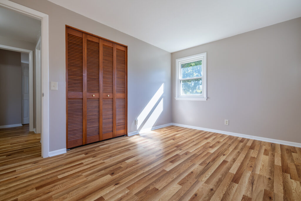 69 Cedarhurst Dr, West Henrietta, NY 14586 5 Bedroom at 69 Cedarhurst Drive with neutral walls, a window, and wood louvered closet doors.
